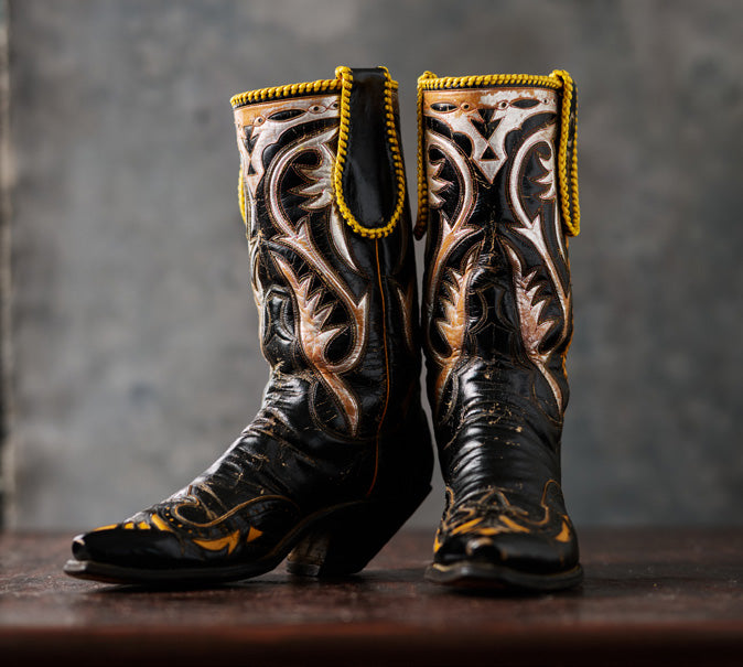 Black cowboy boots with cream and gold inlays, pictured in Western Horseman.